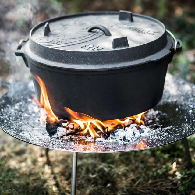Petromax Gusstopf ft12 steht in einem kleinen Holzfeuer auf einer Feuerschale